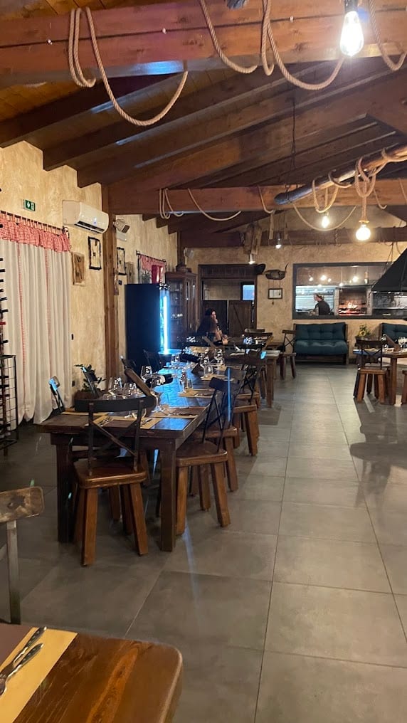 Salón de La Stalla en la noche — luces cálidas y mesas preparadas para la cena