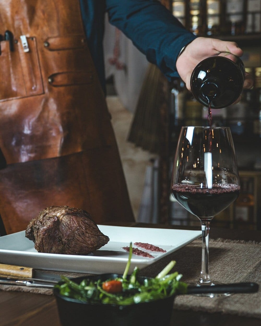 Servicio de vino tinto mientras se sirve la carne — la experiencia completa en La Stalla